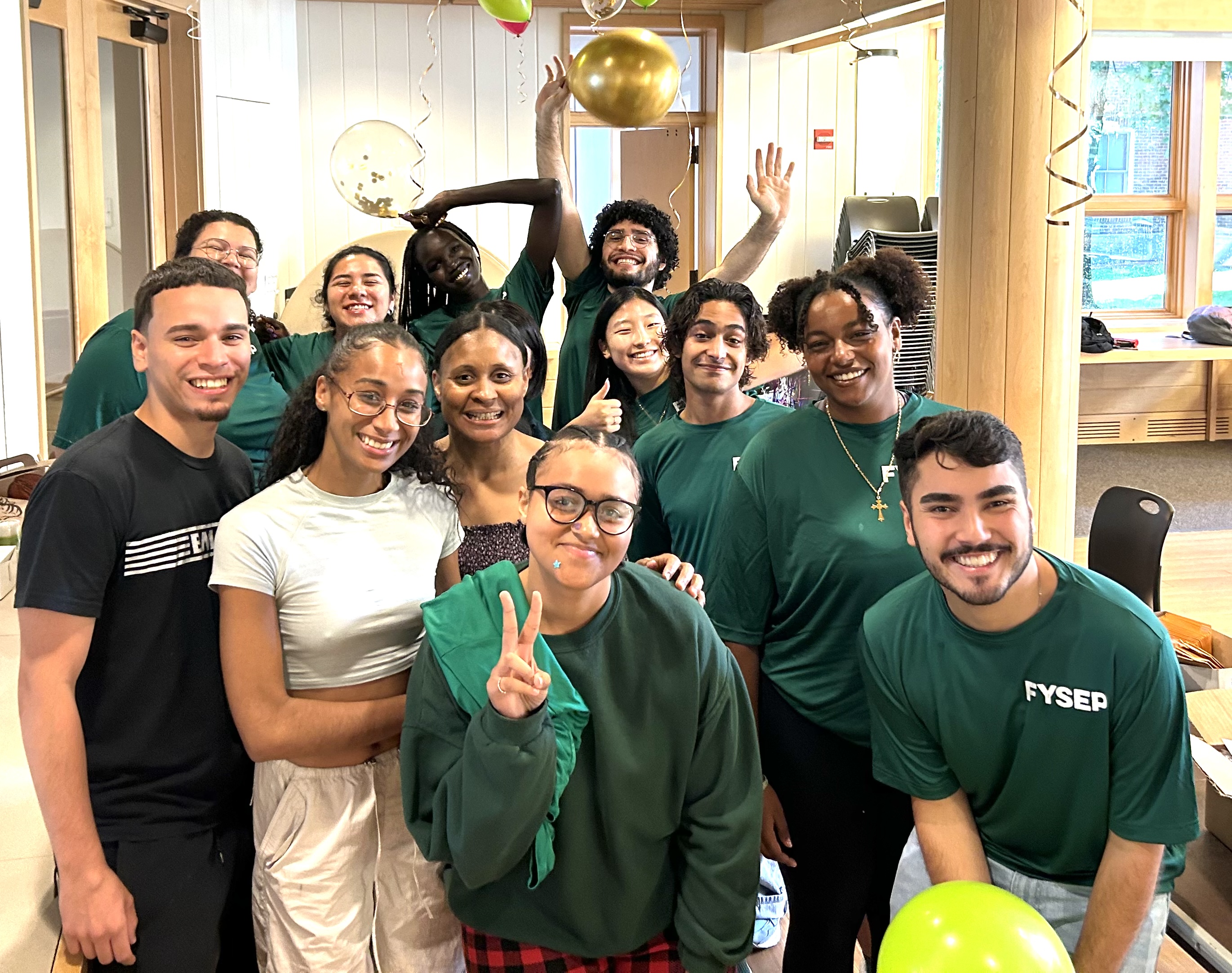 FYSEP mentors smiling brightly and dressed in matching green shirts, radiating enthusiasm and warmth.